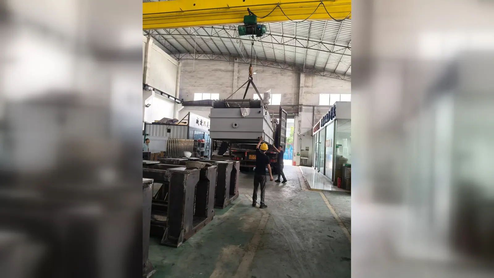 Una sección de la máquina siendo izada durante la operación de carga.